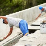 Shot of two construction workers building a rooftop